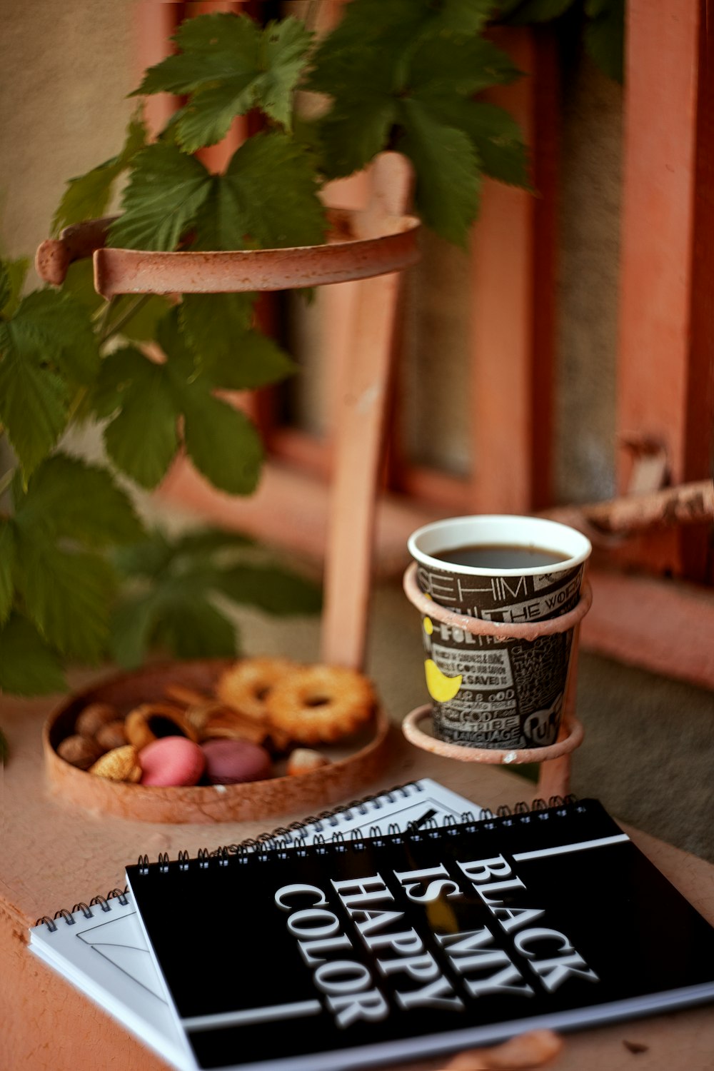 a cup of coffee next to a notebook and a cup of coffee