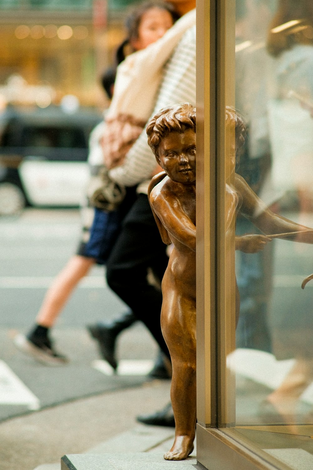 a bronze statue of a boy on a city street