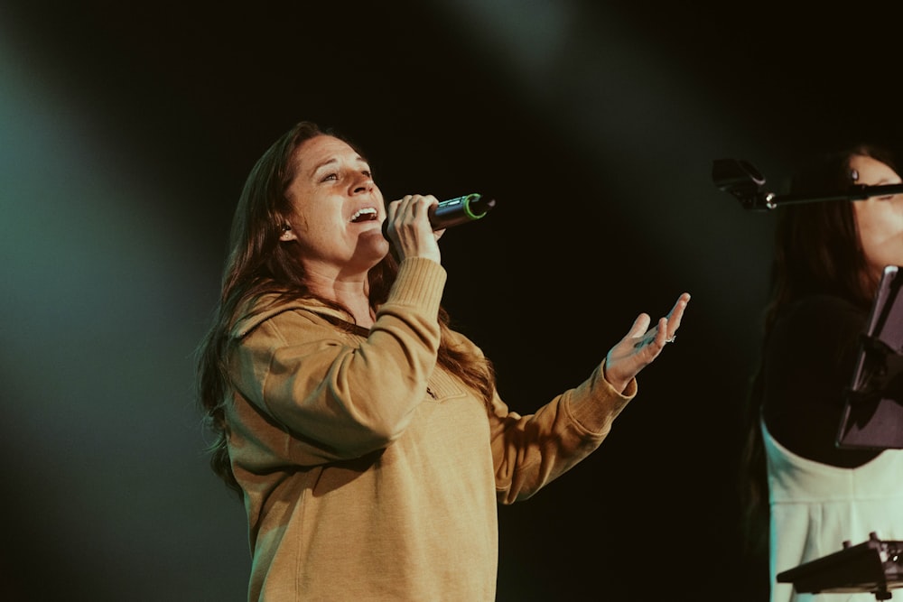 Due donne che cantano nei microfoni sul palco