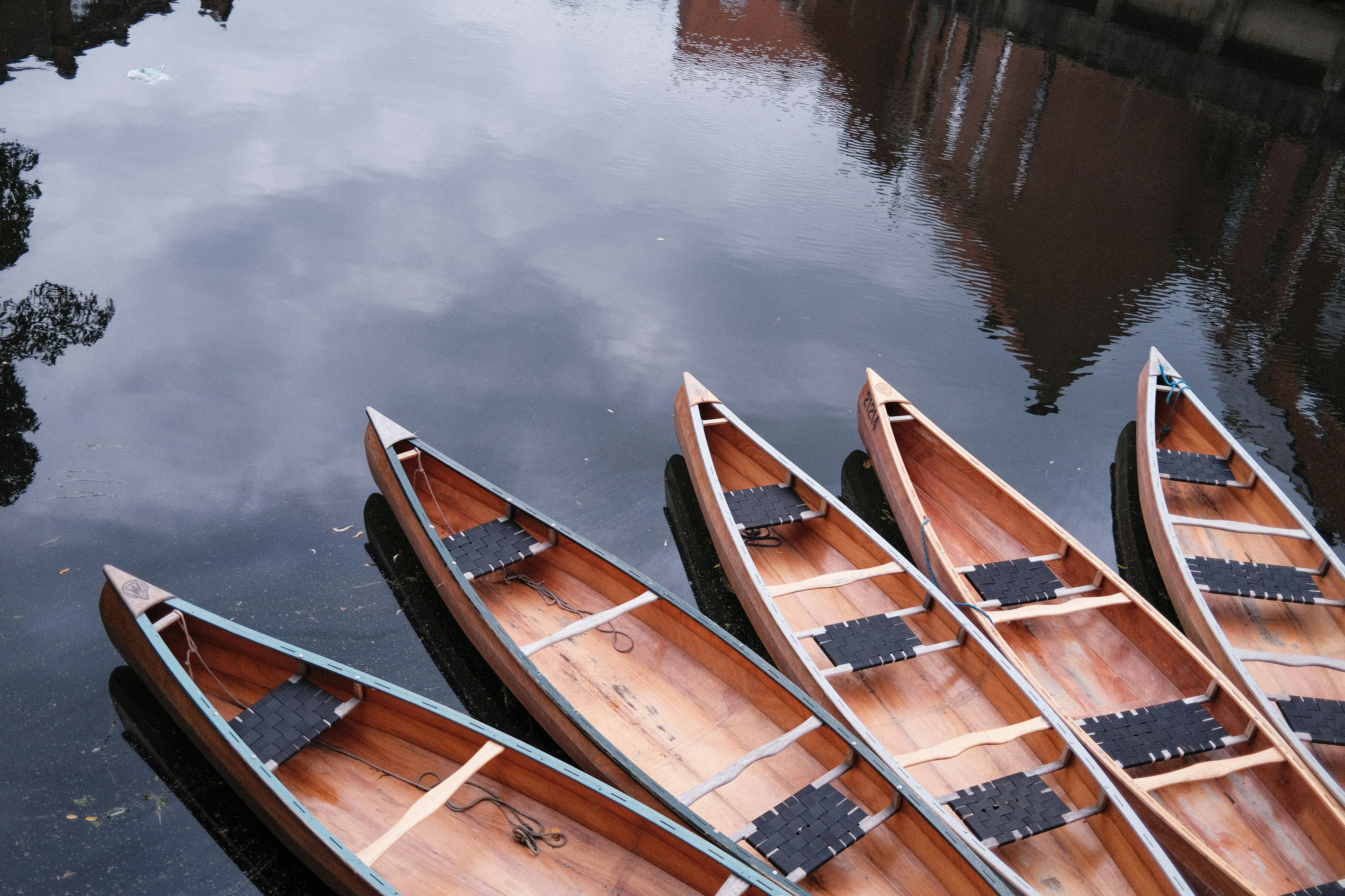 a group of three canoes sitting on top of a body of water