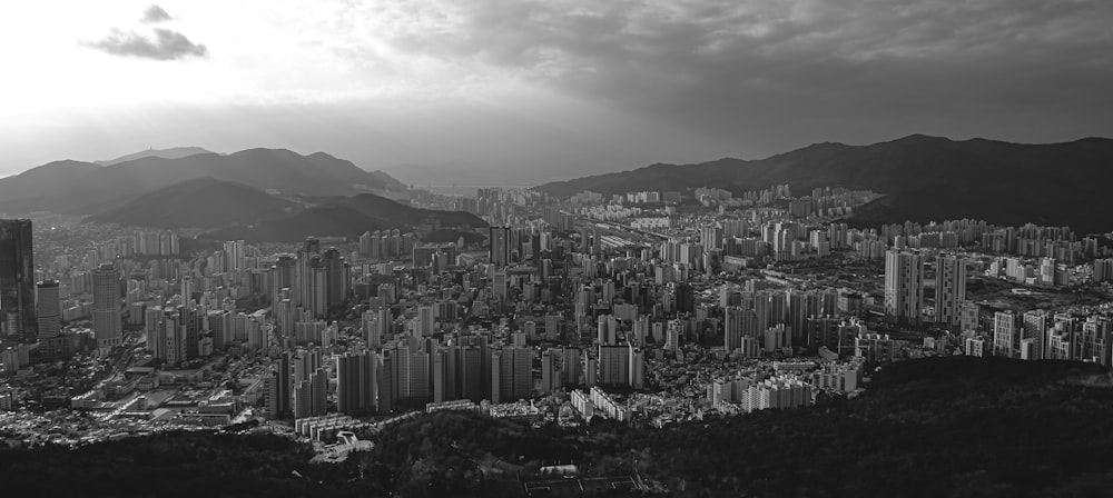 a black and white photo of a city with mountains in the background