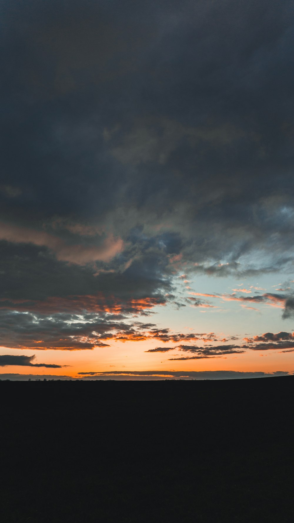 a plane flying in the sky with a sunset in the background