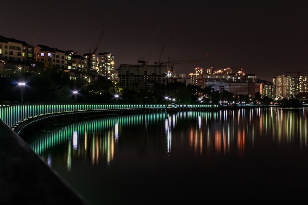 Una veduta notturna di una città con luci che si riflettono nell'acqua
