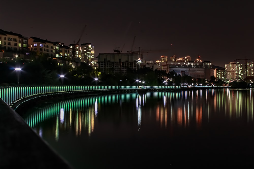 a night view of a city with lights reflecting in the water