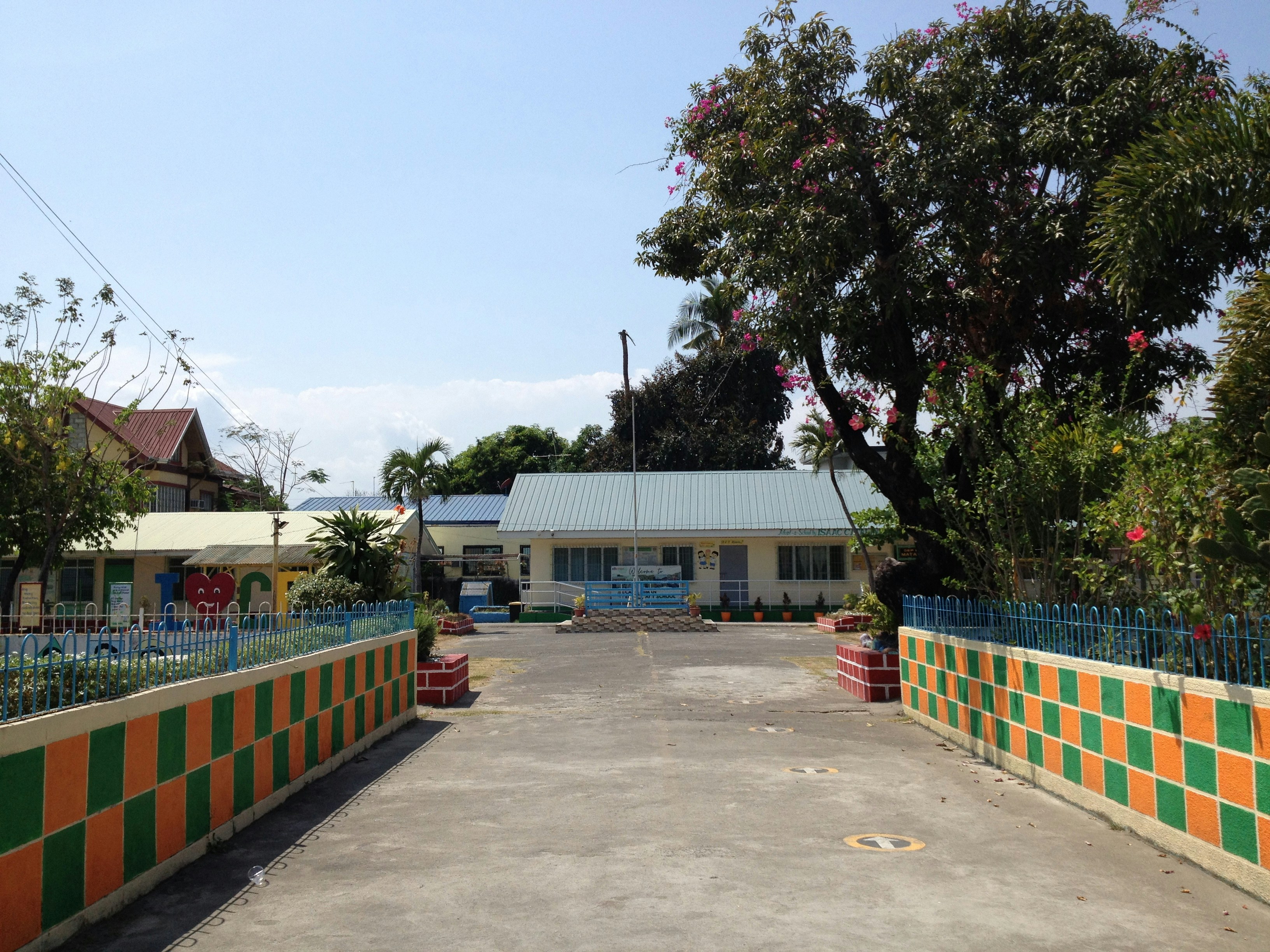a building with a blue roof and orange and green striped fence