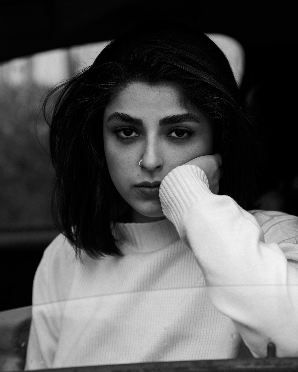 a black and white photo of a woman in a car