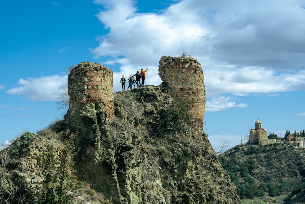 a group of people standing on top of a stone castle