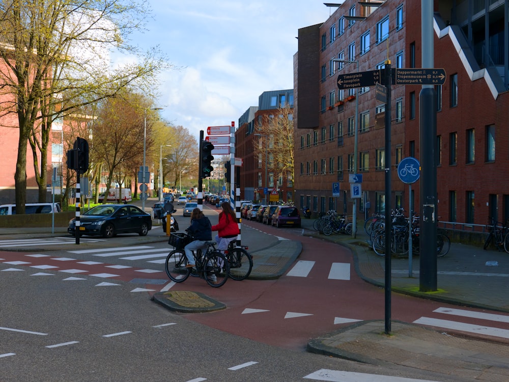 a couple of people riding bikes down a street