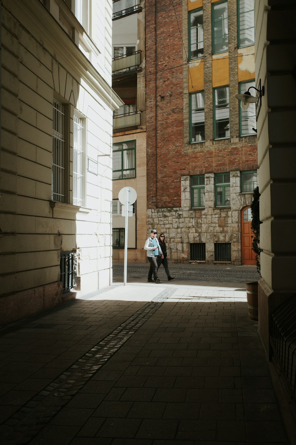 a man walking down a street next to a tall building