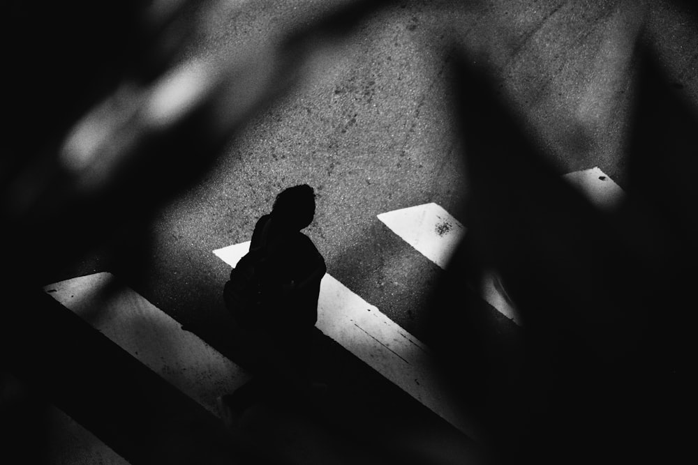 a black and white photo of a person walking down a street