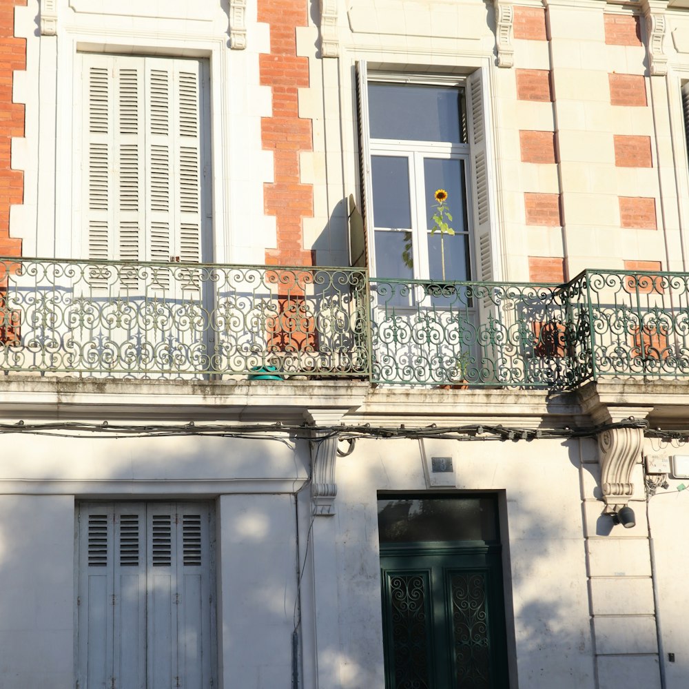 a white building with a balcony and a green door