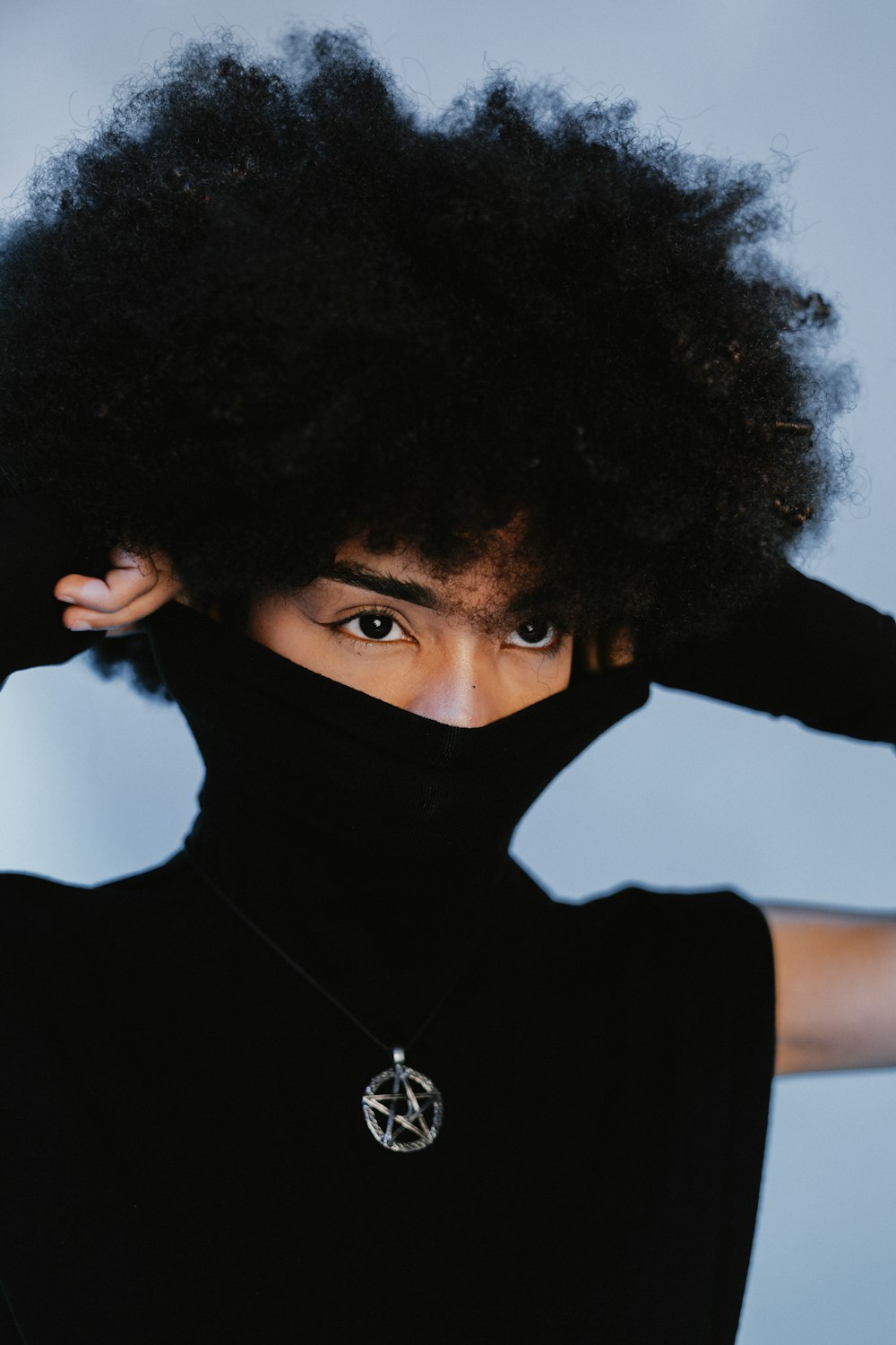 a woman with an afro is covering her face