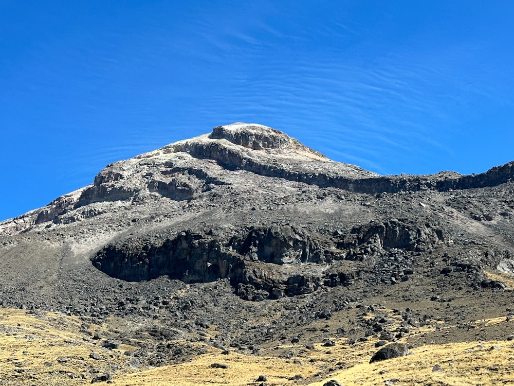 una montaña muy alta con un cielo azul al fondo