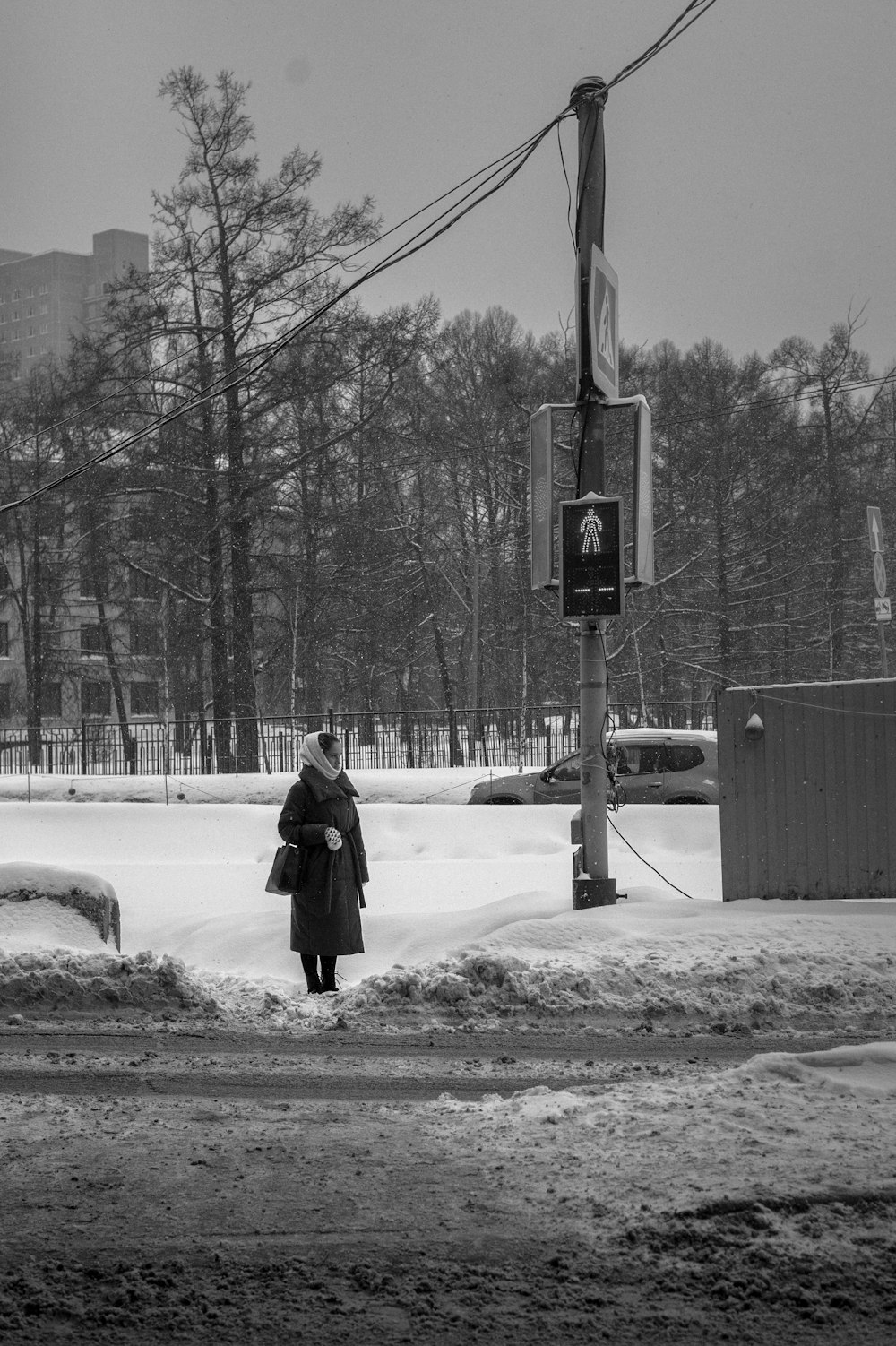 eine Frau, die eine schneebedeckte Straße entlanggeht
