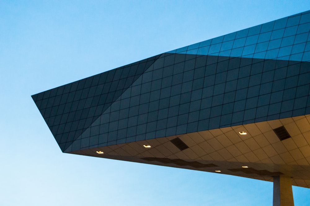 a plane flying over a building with a sky background