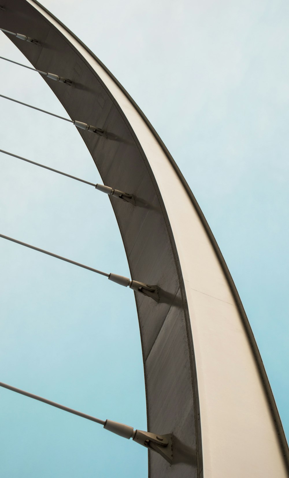 a curved metal structure with a blue sky in the background