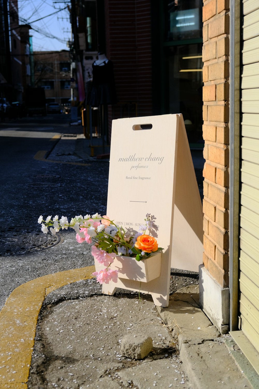 a sign sitting on the side of a road next to a building