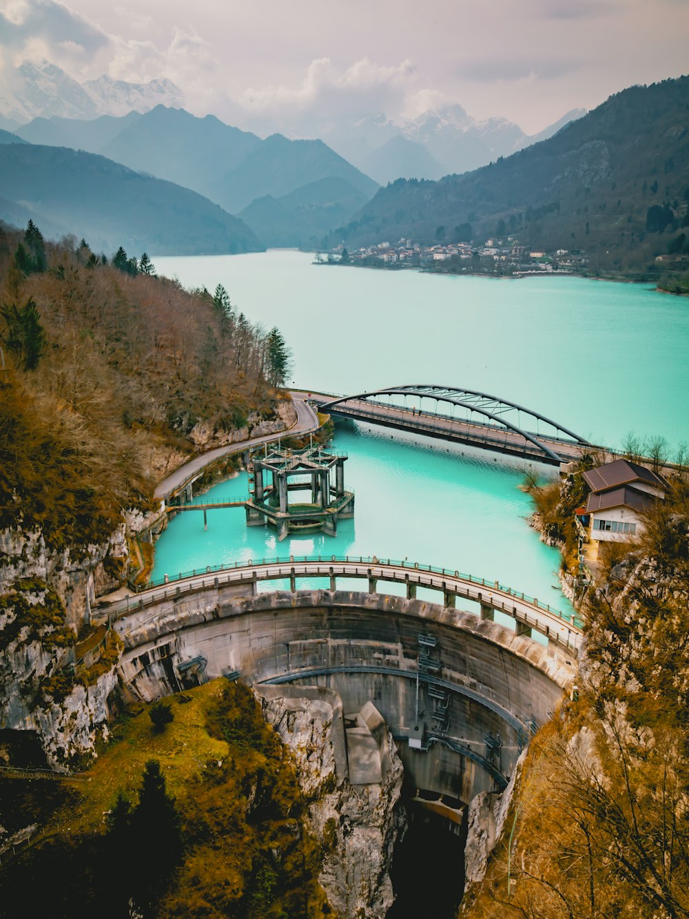 a bridge over a body of water with mountains in the background