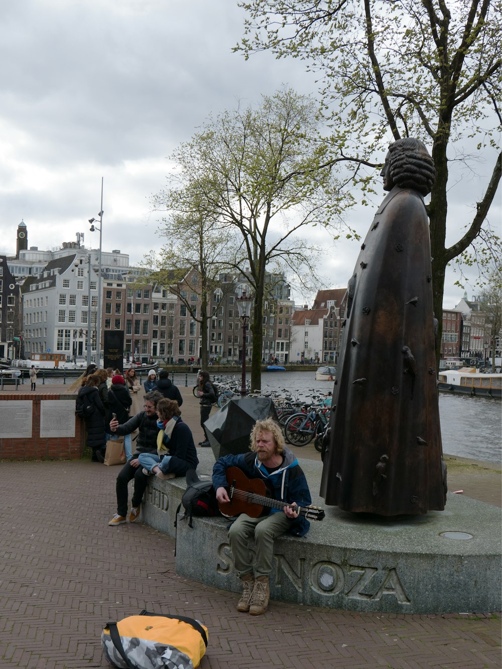 a group of people sitting on a bench next to a statue