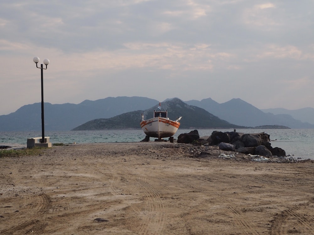 a boat sitting on top of a sandy beach