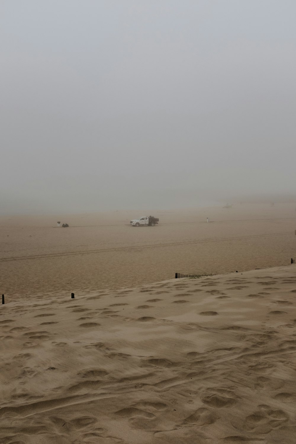 a foggy beach with a boat in the distance