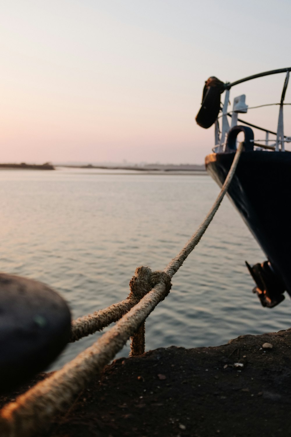 a boat tied up to a dock next to a body of water