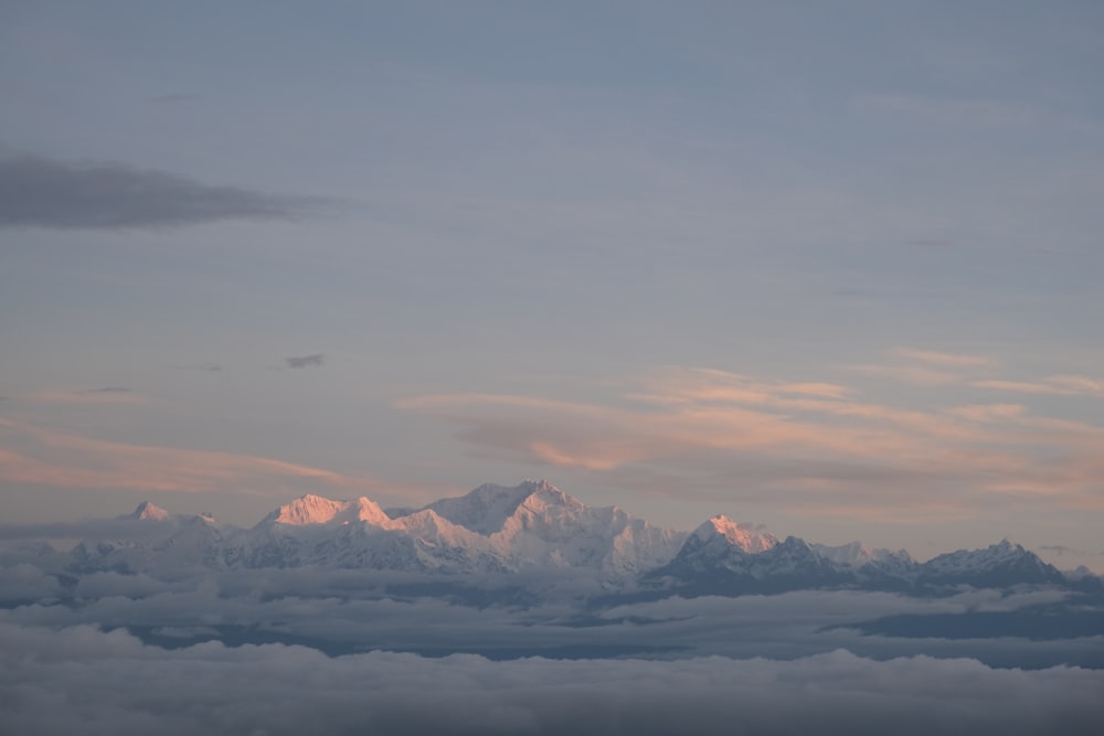 a view of a mountain range with clouds below