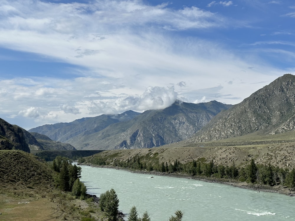 a river running through a valley surrounded by mountains