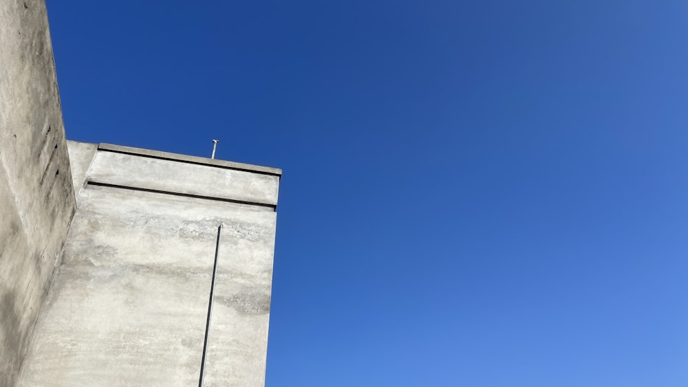 a tall concrete building with a sky in the background