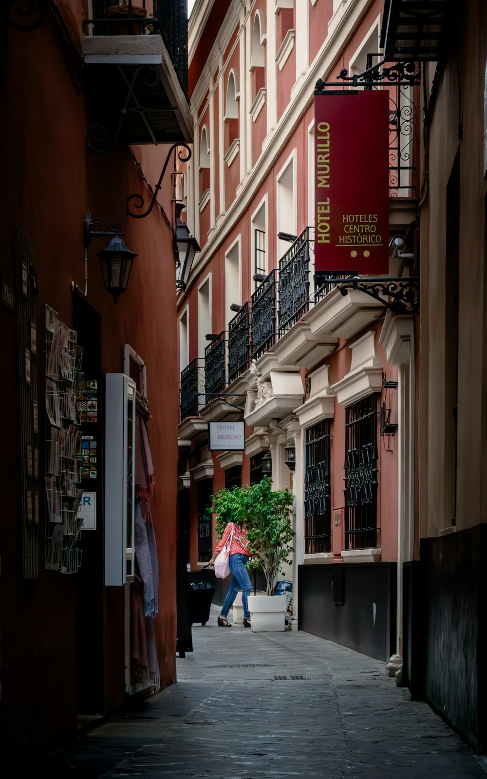 a person walking down a street next to tall buildings