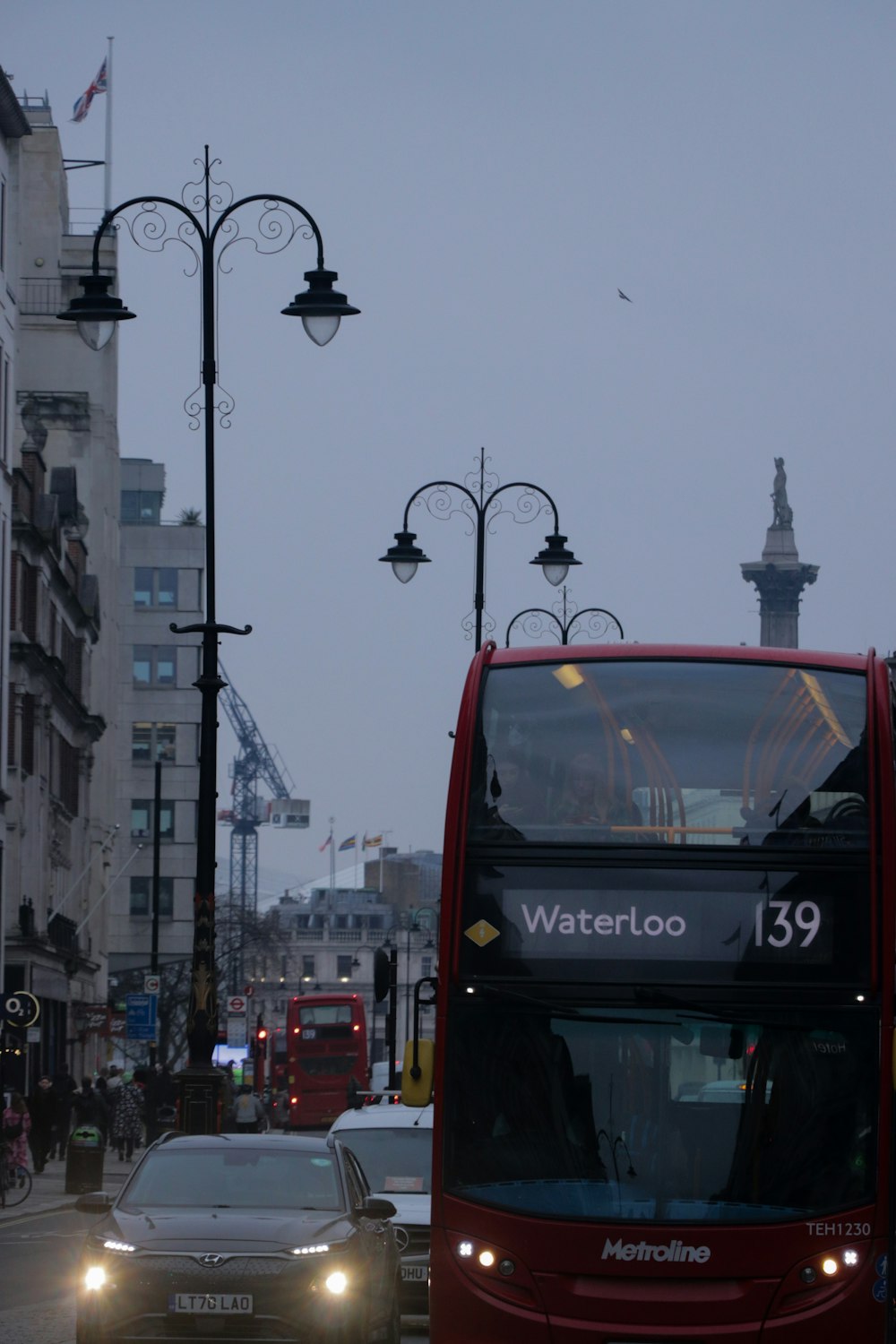 a red double decker bus driving down a street