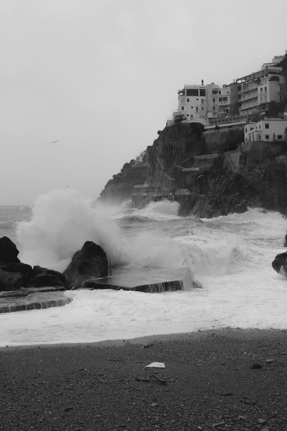 a black and white photo of waves crashing on a rocky beach