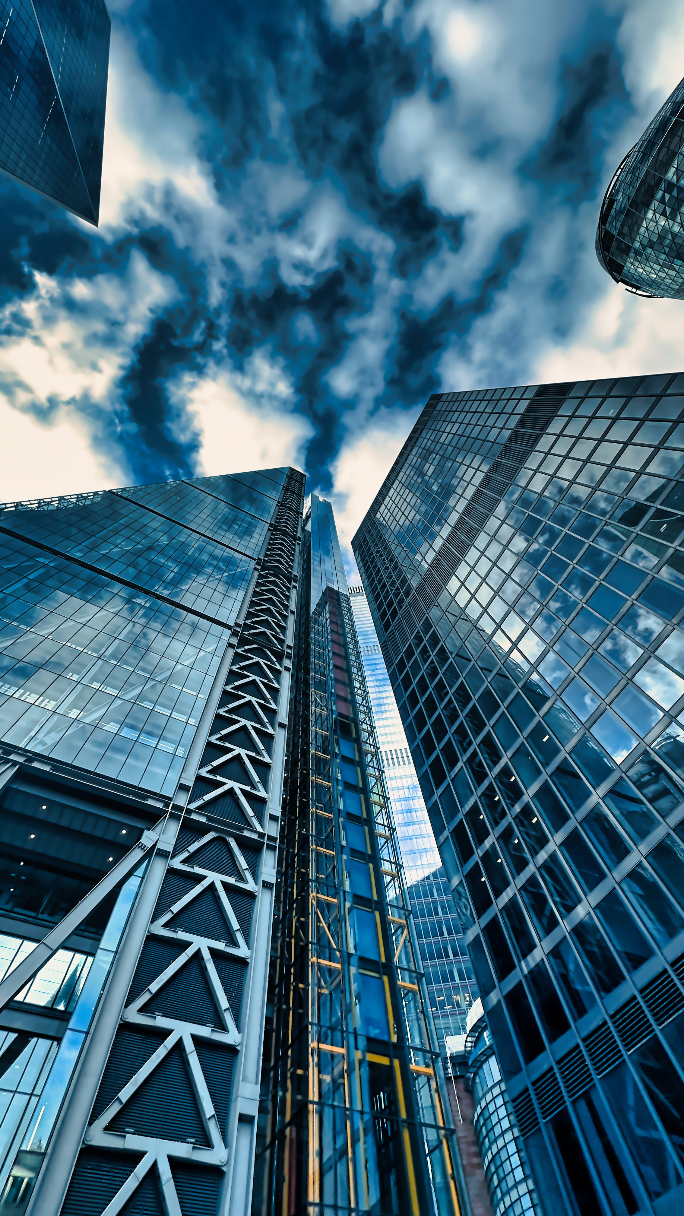 a group of tall buildings with a cloudy sky in the background