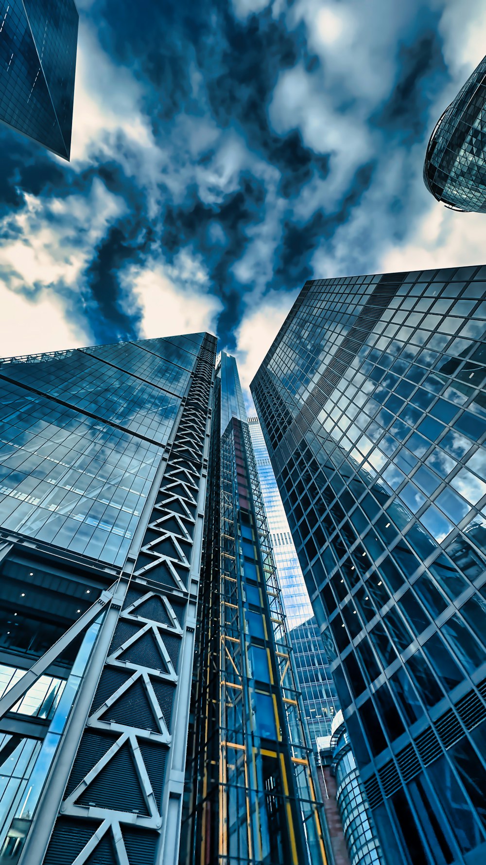 a group of tall buildings with a cloudy sky in the background