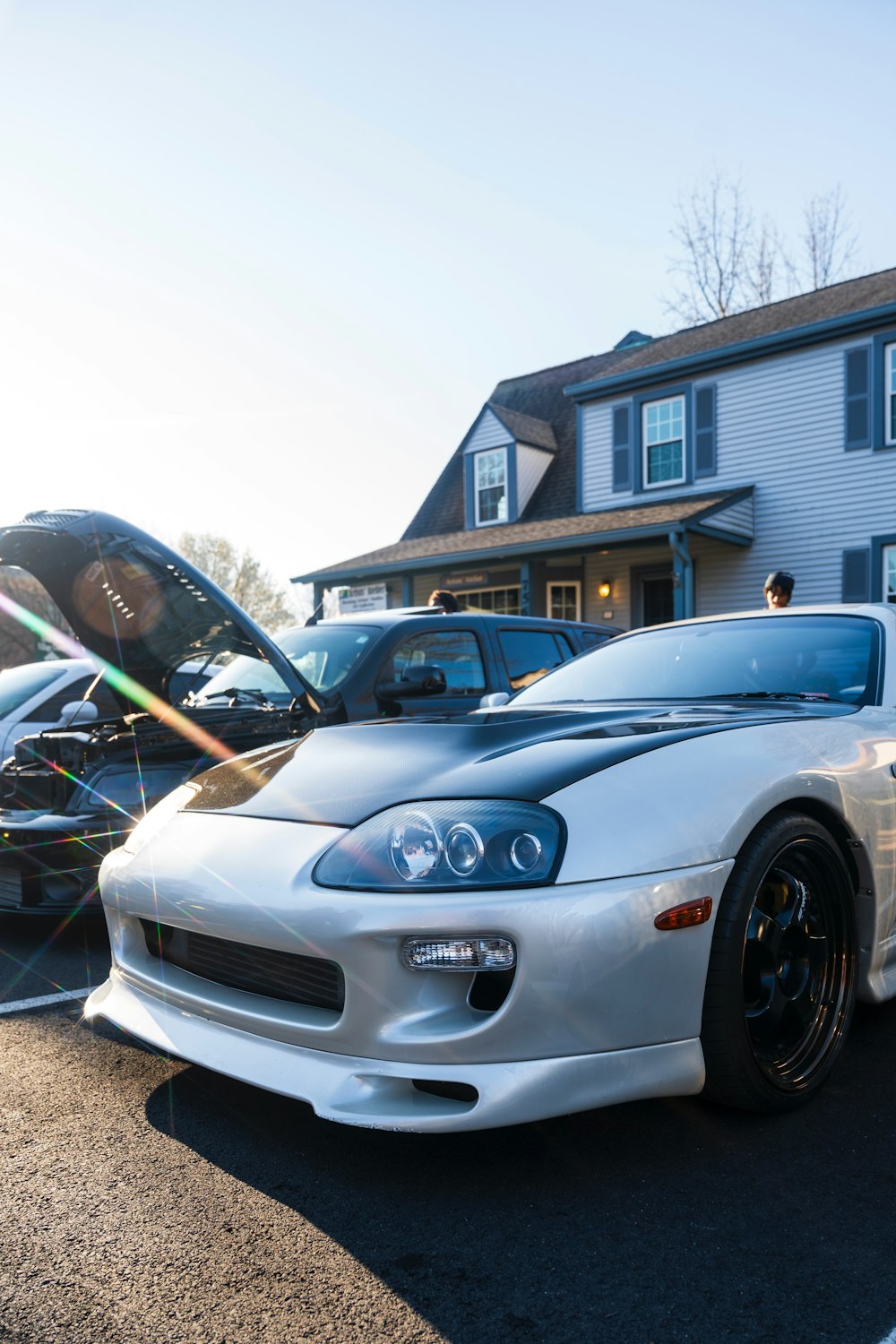 a white sports car parked in front of a house