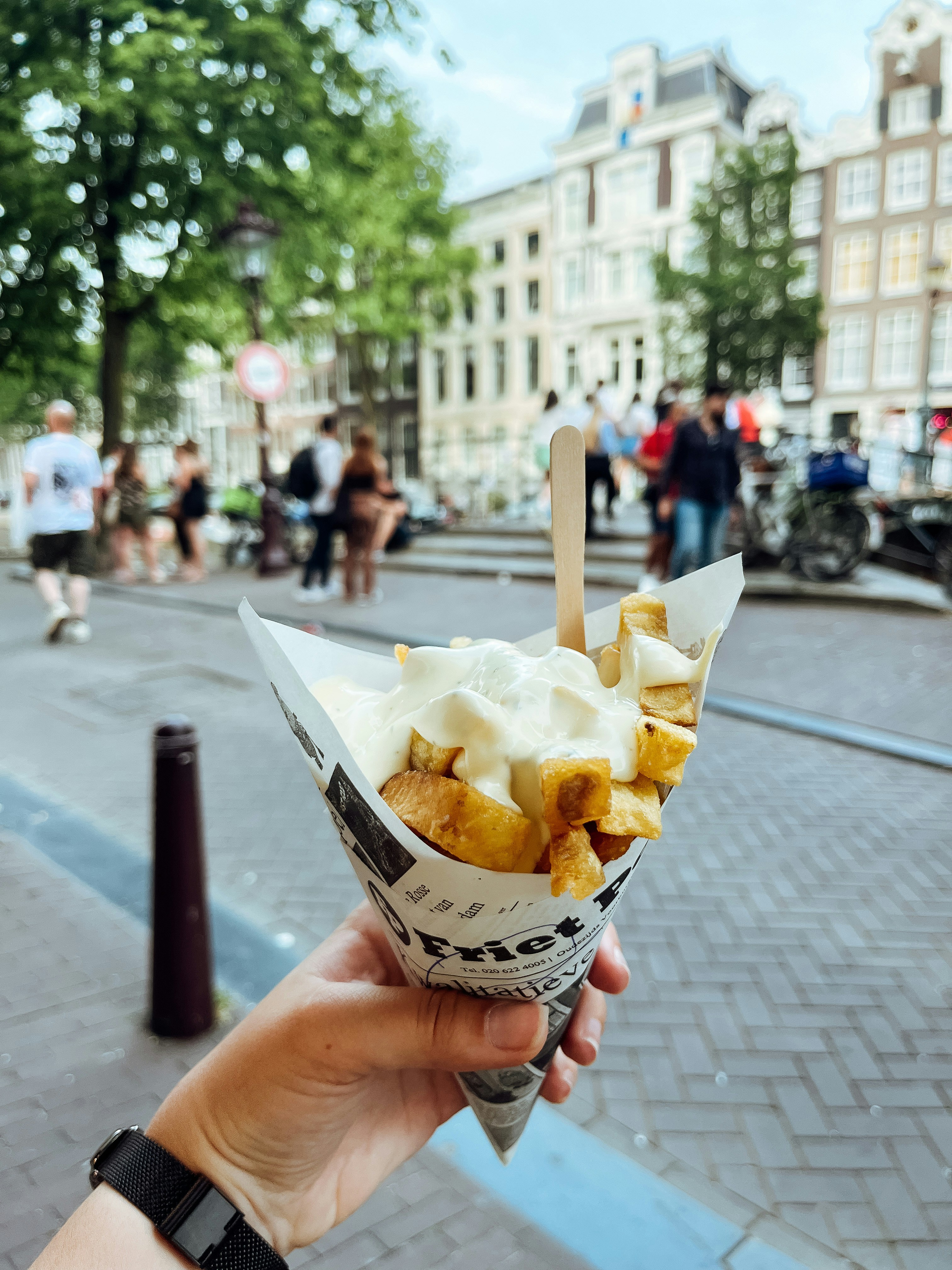 Crispy french fries in paper cone with dipping sauce, dark moody background, warm restaurant lighting