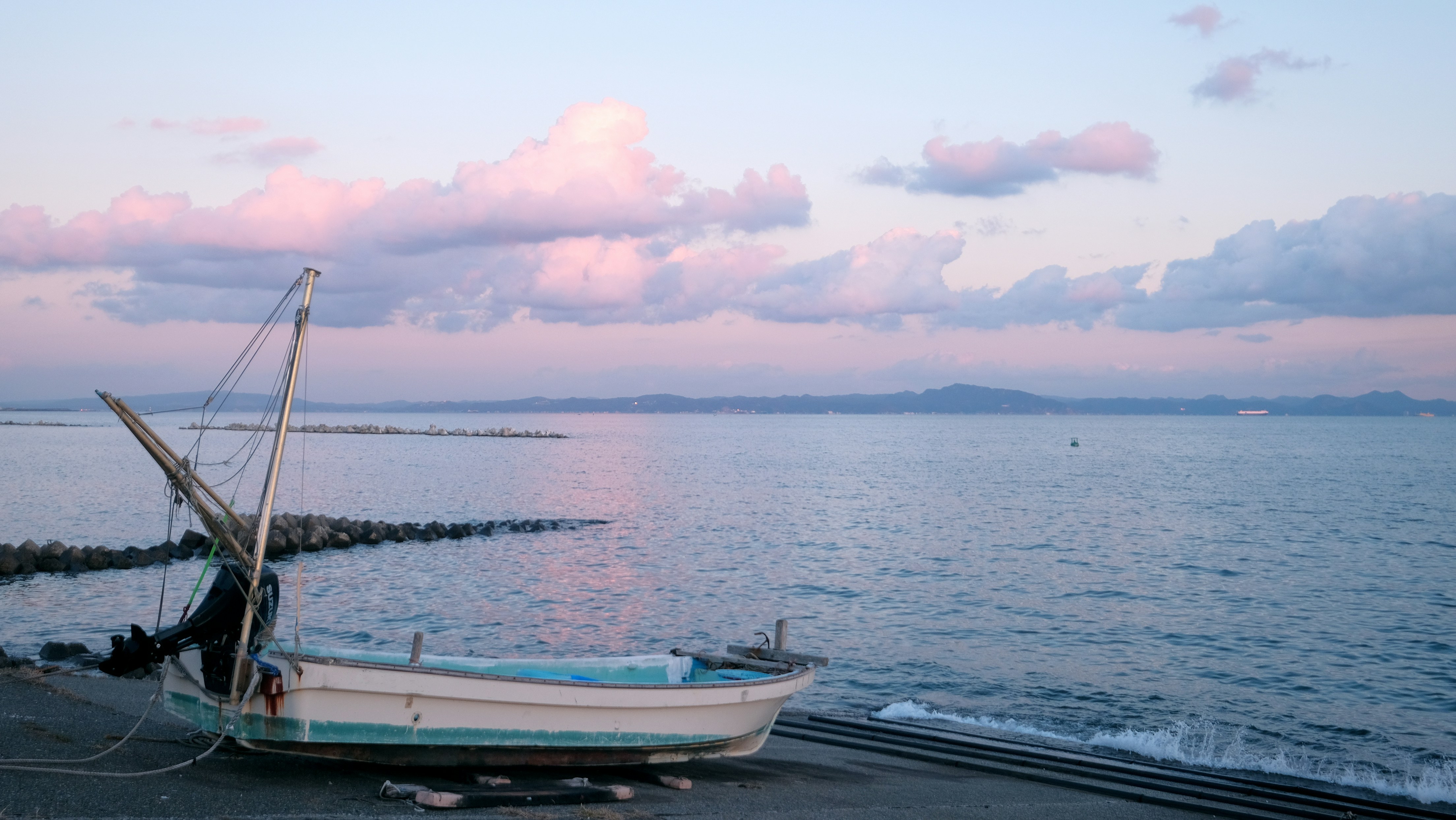 a boat sitting on top of a beach next to the ocean