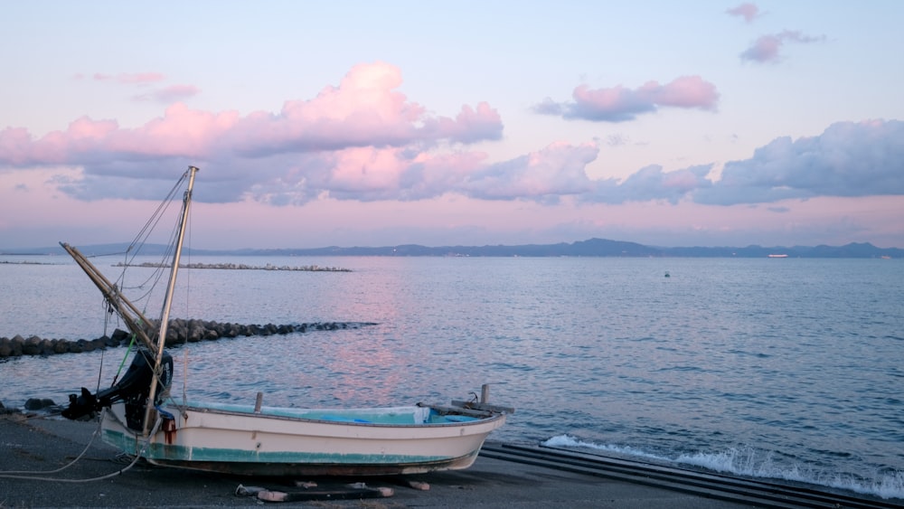 a boat sitting on top of a beach next to the ocean