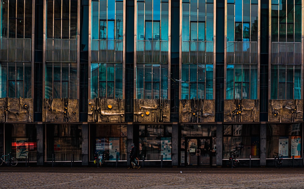 a tall building with lots of windows next to a street