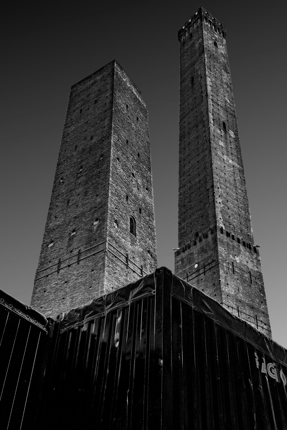 a black and white photo of two tall towers