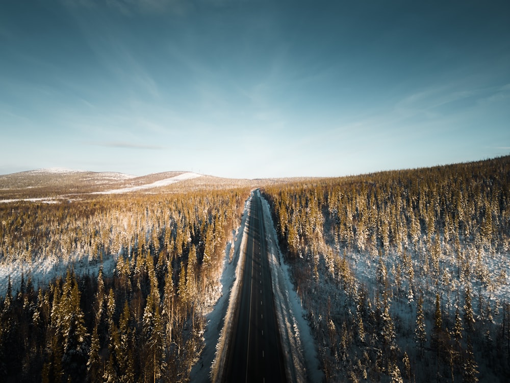an aerial view of a road in the middle of a snowy field