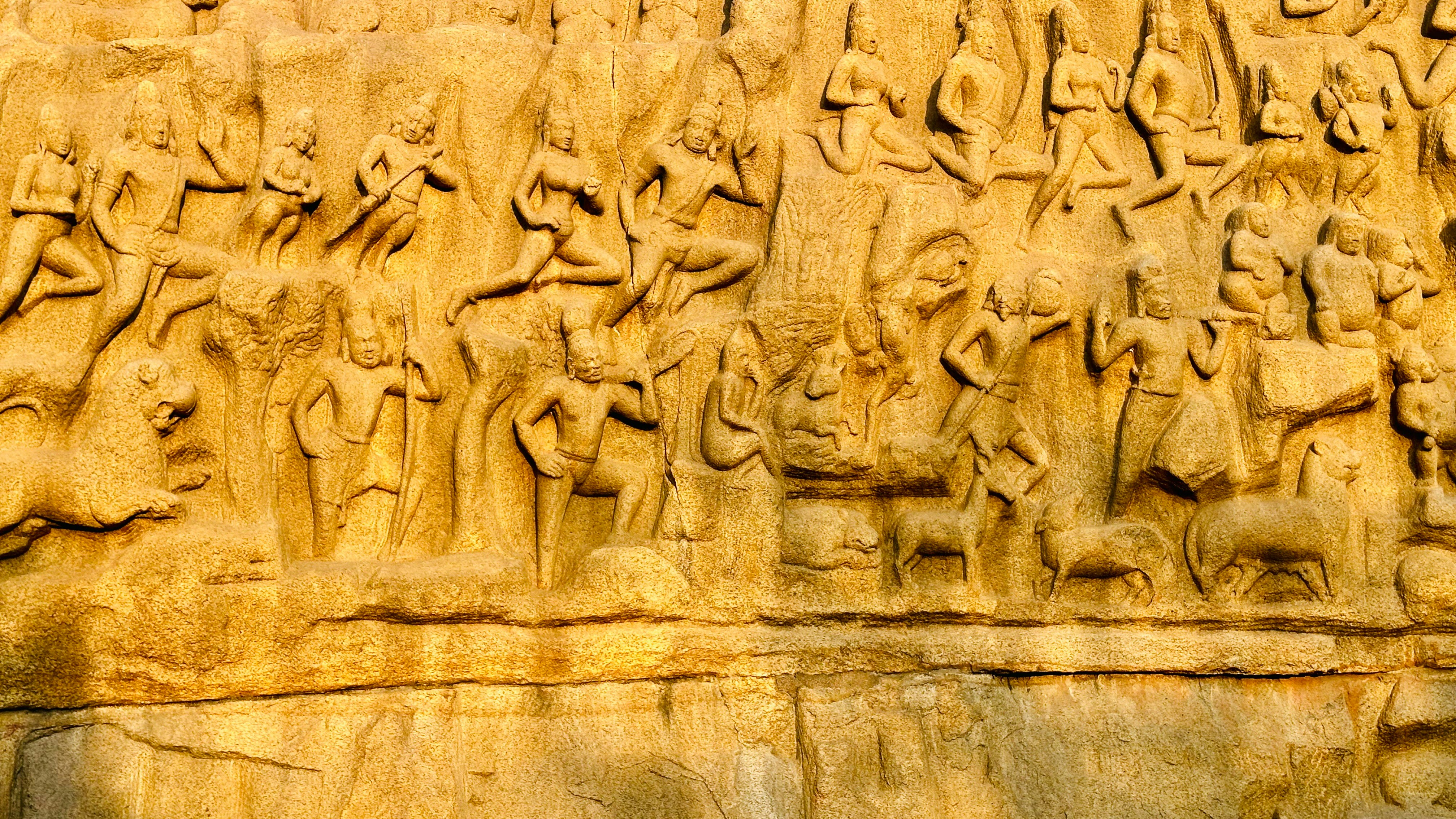 a stone wall with carvings of people and animals on it