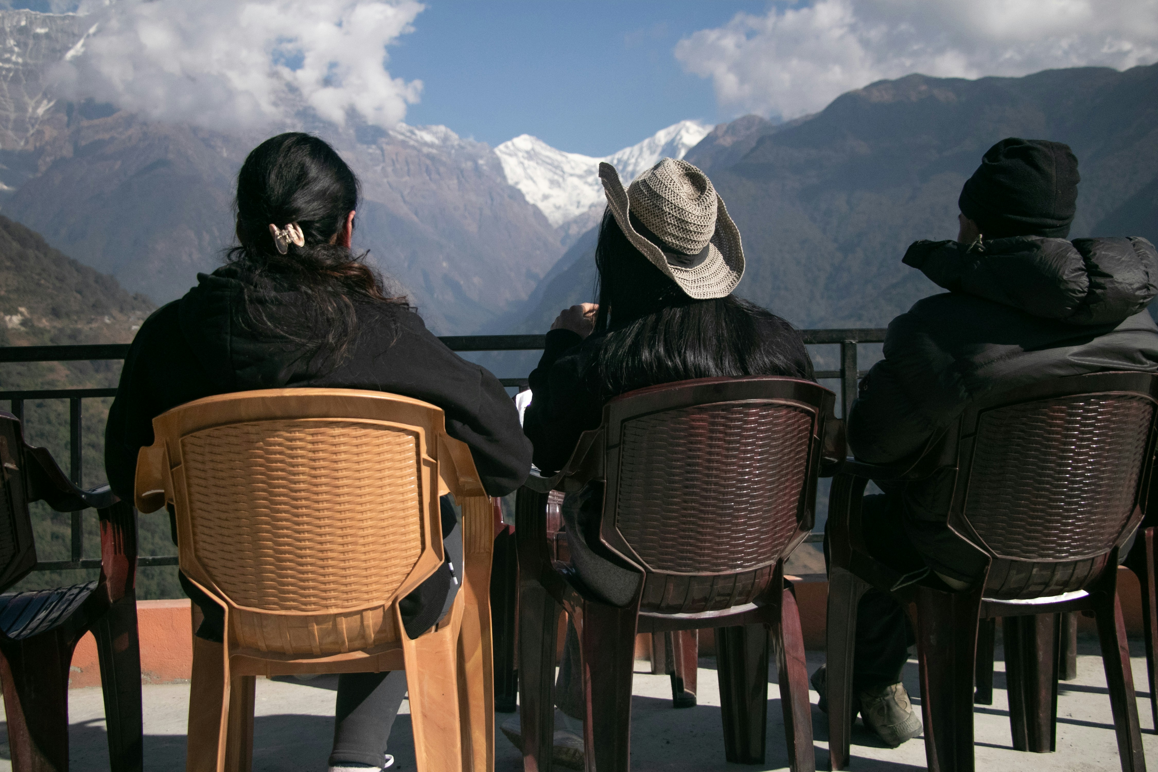 a group of people sitting at a table with mountains in the background
