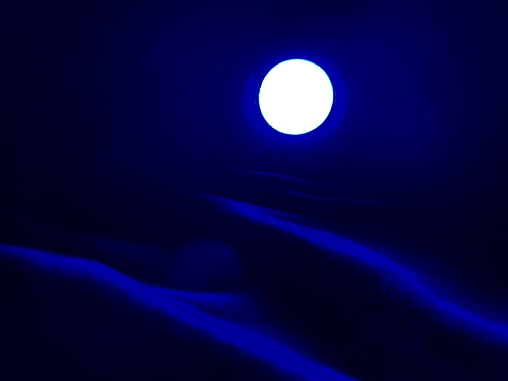 a bright blue light shines in the dark