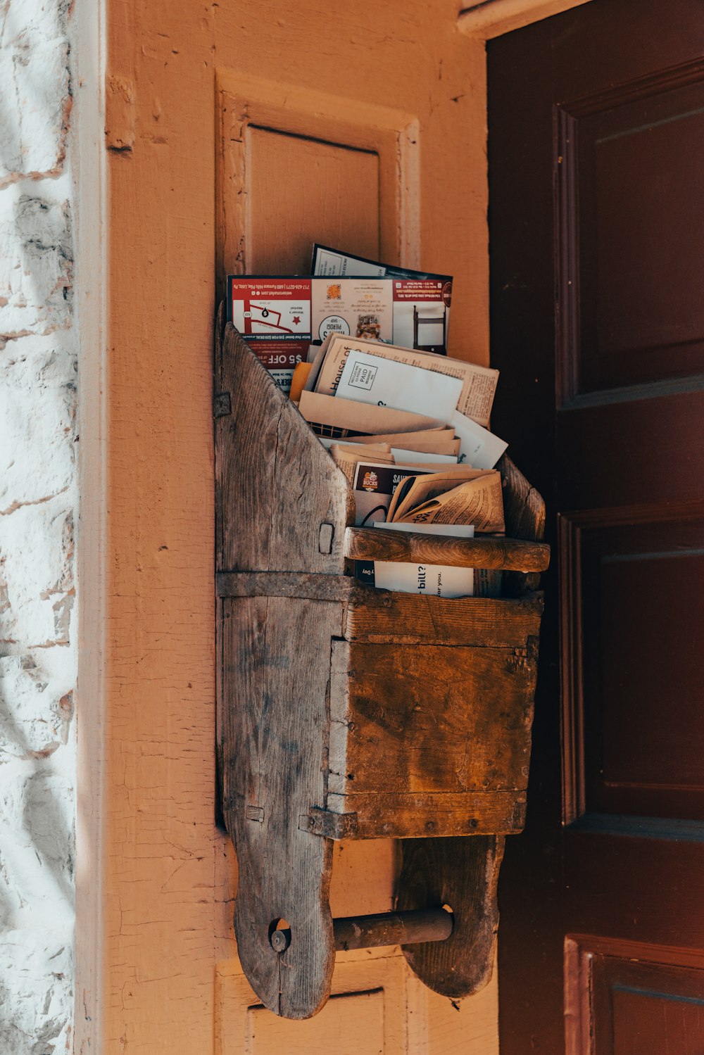 a wooden box filled with books sitting on top of a door