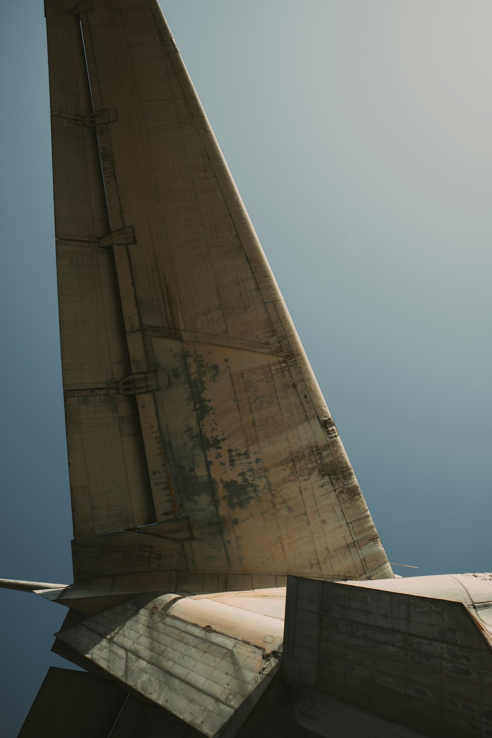 the tail end of an airplane against a blue sky