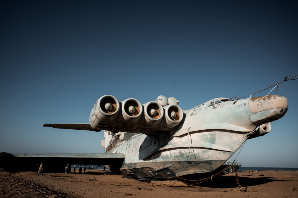 ein großes Flugzeug, das auf einem Sandstrand sitzt