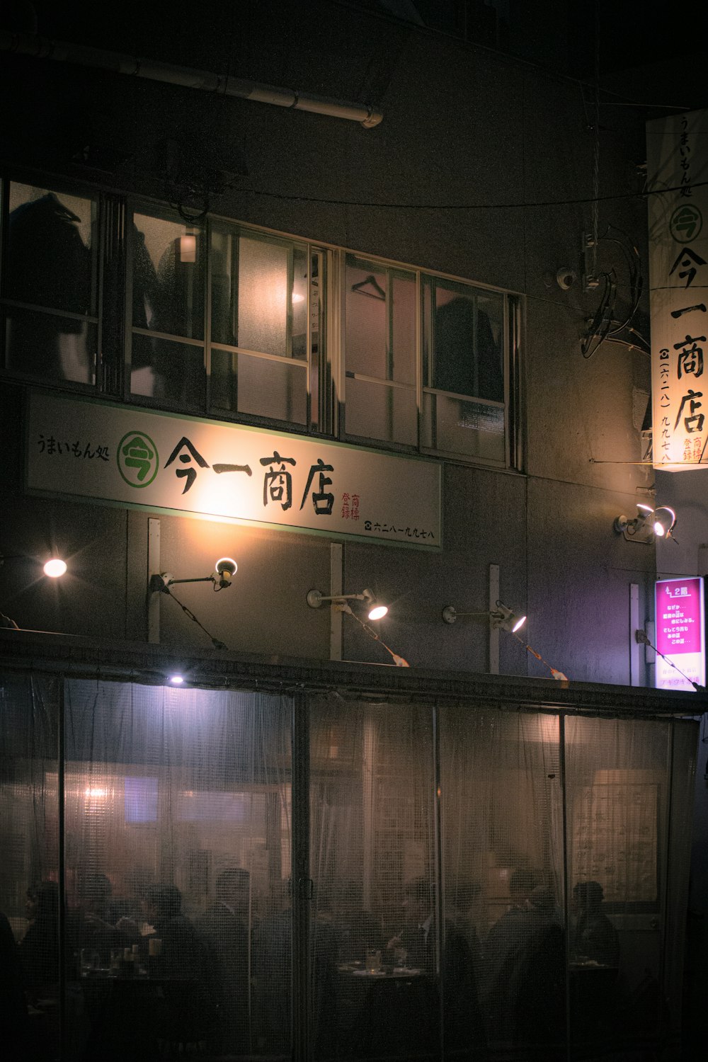 a group of people standing outside of a building at night