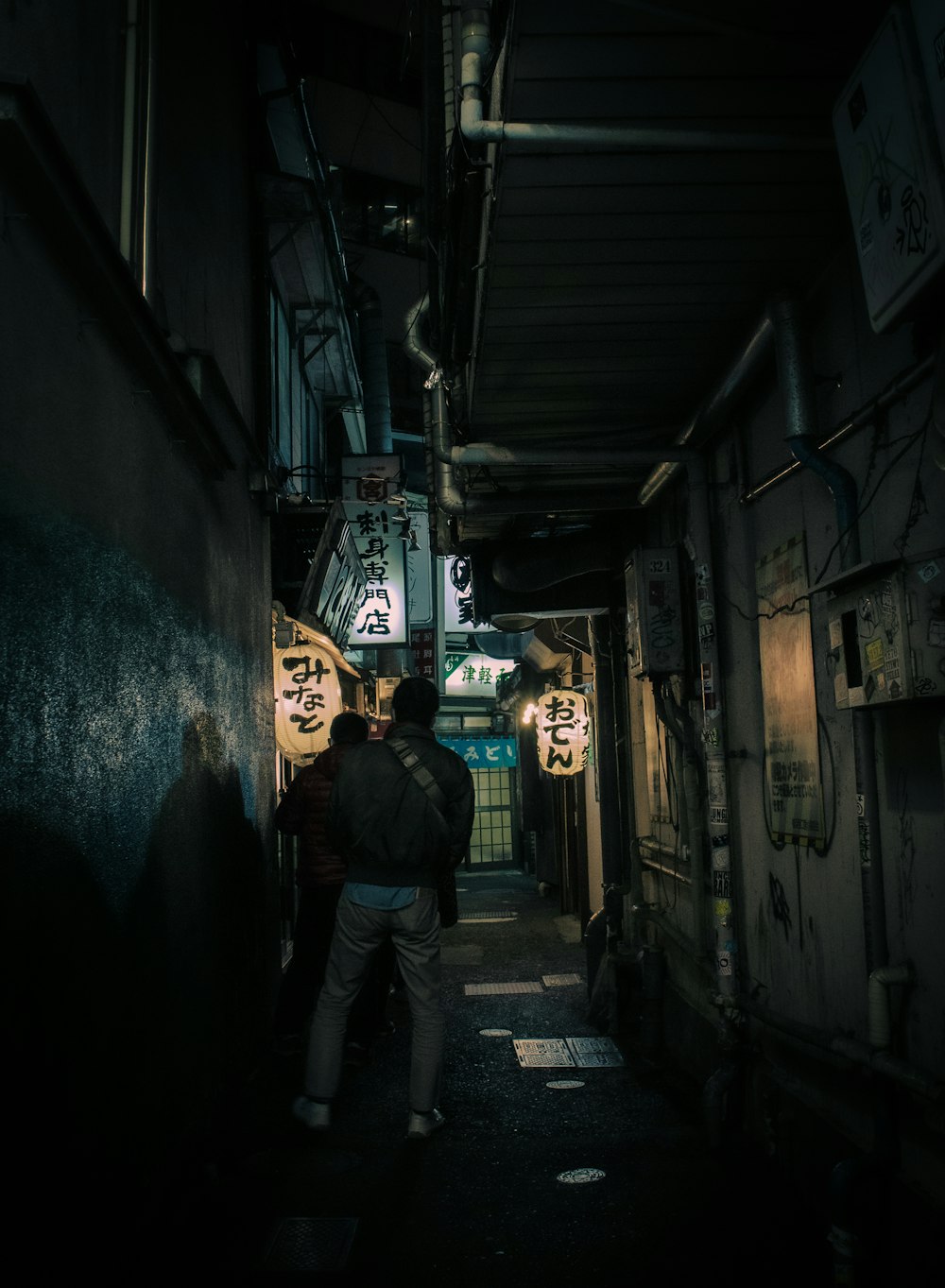 un homme marchant dans une ruelle sombre