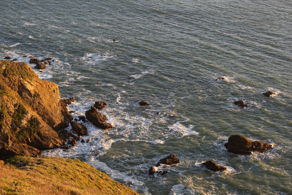 a body of water surrounded by rocks and grass